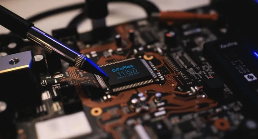 Close-up view of a circuit board with a prominent microchip labeled 'GigaPlatz 11153' and a tool for adjustment.